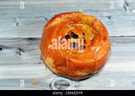 Roulé à la cannelle, roulé, sucré avec du miel et des raisins secs et rempli de crème anglaise cuite, concentré de sélection de pâtisseries croissant roulé de boulangerie dan Banque D'Images