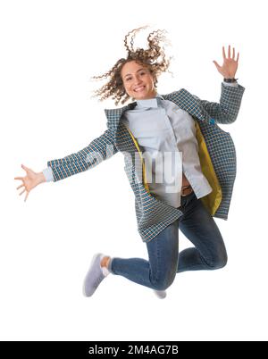 Belle jeune fille dans un manteau léger sautant sur fond blanc Banque D'Images