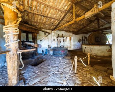 Broyeur de pétrole - musée en plein air aux grottes de Scurati ou « Grotta Mangiapane » un ancien village habité depuis le Paléolithique supérieur, montrant les traditions artisanales et la vie rurale en Sicile - Custonaci, Sicile, Italie Banque D'Images