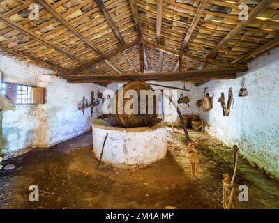 Broyeur de pétrole - musée en plein air aux grottes de Scurati ou « Grotta Mangiapane » un ancien village habité depuis le Paléolithique supérieur, montrant les traditions artisanales et la vie rurale en Sicile - Custonaci, Sicile, Italie Banque D'Images