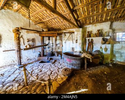 Broyeur de pétrole - musée en plein air aux grottes de Scurati ou « Grotta Mangiapane » un ancien village habité depuis le Paléolithique supérieur, montrant les traditions artisanales et la vie rurale en Sicile - Custonaci, Sicile, Italie Banque D'Images