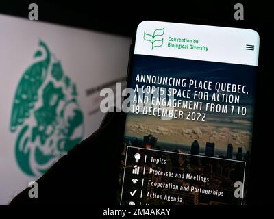 Personne tenant un smartphone avec la page web de la conférence de la biodiversité CBD COP 15 à Montréal sur écran avec logo. Concentrez-vous sur le centre de l'écran du téléphone. Banque D'Images