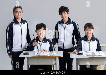 Étudiants chinois pratiquant la calligraphie en classe Banque D'Images