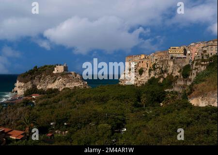 Une végétation dense remplit maintenant les terres naturellement récupérées entre la vieille ville de Tropea, sur la côte ouest de la mer Tyrrhénienne de la Calabre, dans le sud de l'Italie, et le promontoire rocheux, autrefois une île, portant le Sanctuaire de Santa Maria dell'Isola, reconstruit plusieurs fois sur le site d'un ancien monastère chrétien. Banque D'Images