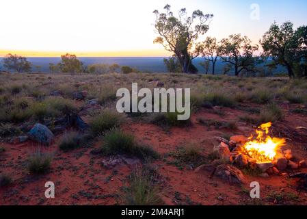 Enflammé par le vent, un feu de camp brûle sur un site de camp de l'outback, au sommet du mont Oxley, dans l'outback nord-ouest de la Nouvelle-Galles du Sud, en Australie Banque D'Images
