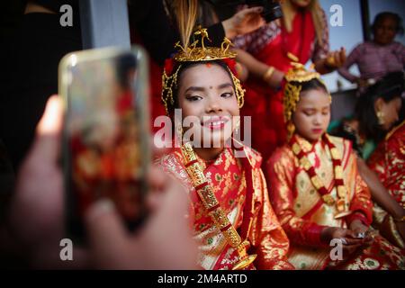 Népal. 20th décembre 2022. Une petite fille exécute un rituel traditionnel avec ses amis lors de leur cérémonie Gufa à Bhaktapur lundi. Gufa, une culture traditionnelle de la communauté Newar où les filles âgées entre 12-14 ans sont mariées à Sun God avant sa première mensur. La fille portant le rituel doit résider pendant 12 jours tout en évitant le Soleil et les membres masculins de la famille. Après l'achèvement du processus, le 12th jour, la fille est sortie de la salle et a demandé à regarder le soleil.Â cette tradition a la signification de montrer le changement du cycle de vie de la g Banque D'Images