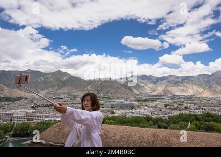 Le touriste chinois prend un selfie avec la ville de Lhassa en arrière-plan. Région autonome du Tibet. Chine. Banque D'Images