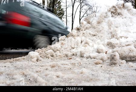 Munich, Allemagne. 20th décembre 2022. Une voiture roule à côté d'une pile de neige sur une route dégagée. Credit: Sven Hoppe/dpa/Alay Live News Banque D'Images