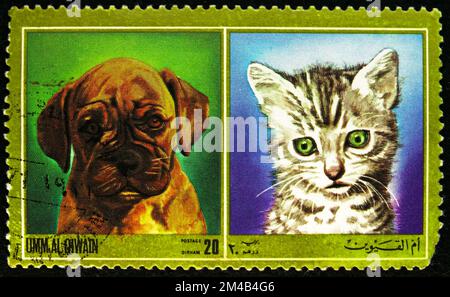 MOSCOU, RUSSIE - 29 OCTOBRE 2022 : timbre-poste imprimé à Umm Al Quwain montre chien et chat, série, vers 1972 Banque D'Images