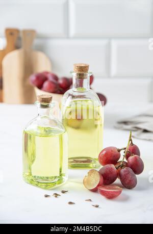 huile de pépins de raisin végétalien et diététique naturelle en bouteilles de verre sur fond de marbre blanc. Une alimentation saine et un mode de vie sain. Vue avant Banque D'Images