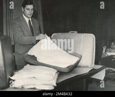 Un agent du Bureau fédéral des stupéfiants qui fonde la drogue dans le double fond de la valise, USA 1950s Banque D'Images