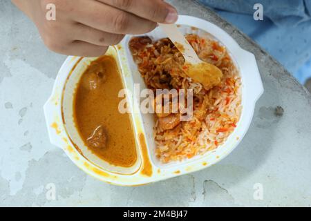 curry de poulet et de riz dans un sachet en plastique à emporter sur la table Banque D'Images