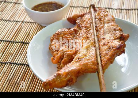 bâton de bois de poulet rôti sur plaque trempée avec sauce épicée Banque D'Images