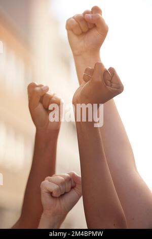 Mains poing et justice du pouvoir par les gens en signe de protestation pour la liberté, l'égalité et le changement dans une rue. Communauté, action et le rassemblement du gouvernement par l'homme et Banque D'Images