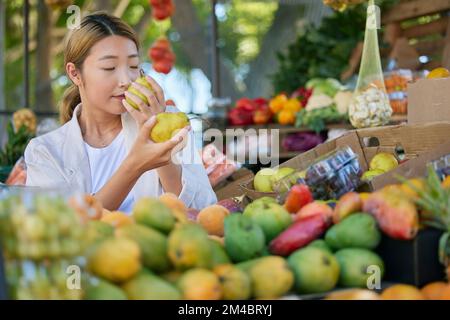 Fruits, nourriture et femme au Japon marché pour le choix de qualité, la nutrition et le shopping sain dans vert, magasin écologique. Marché extérieur, poire et Banque D'Images