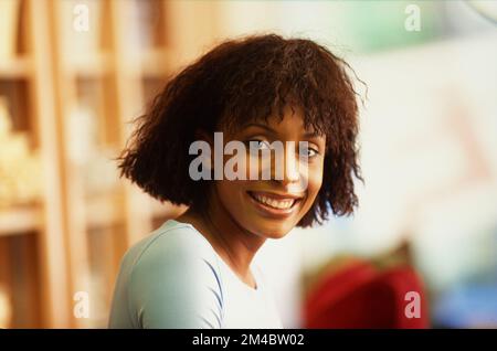 Femme afro-américaine plus jeune souriant à la caméra Banque D'Images