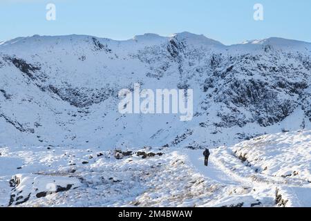 Une seule personne sur le chemin des mineurs jusqu'au sommet du mont Snowdon, par une belle journée d'hiver. Banque D'Images