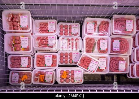 Viande de porc crue dans le comptoir réfrigéré pour la vente dans le supermarché italien, saucisses, boulettes de viande et kebabs dans les plateaux de plastique alimentaire avec poids et prix labe Banque D'Images