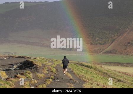 Aberystwyth pays de Galles Royaume-Uni météo 20th décembre 2022, boursoufrant avec des douches sur la côte ouest, les gens marchent les chiens lors d'un doux jour d'hiver un arc-en-ciel apparaît, Credit: mike davies/Alay Live News Banque D'Images