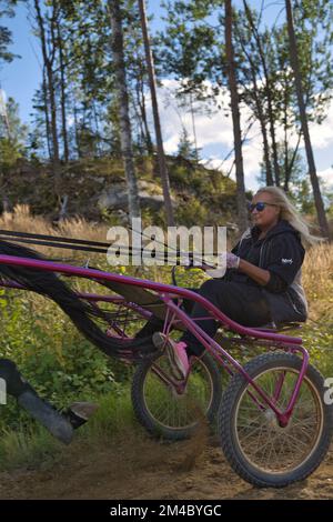 Lady forme un cheval assis dans un soyeux sur une piste. Photo de haute qualité Banque D'Images