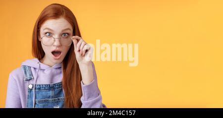 Choc impressionné collègue redhead entendre les dernières rumeurs intimes lâcher mâchoire regarder plein l'incrédulité de l'appareil photo confus les lunettes de contact semblent incertains la vérité mentir Banque D'Images