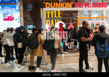 Les visiteurs des chantiers de Hudson à New York jeudi, 15 décembre 2022 font la queue pour une activation de marque hors du jeu et reçoivent gratuitement des échantillons de latte Signature mocha à la menthe poivrée, des cartes-cadeaux et des friandises au salon de récompenses Dunkin'. (© Richard B. Levine) Banque D'Images