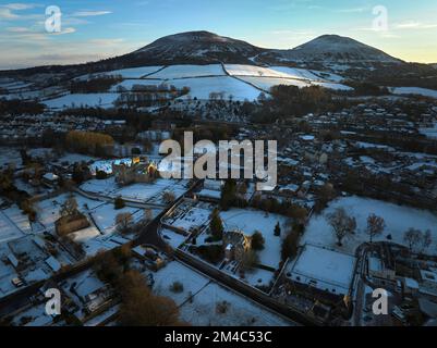 Prise de vue aérienne de l'abbaye de Melrose, de Harmony House et des Eildons avec une couche de neige et de givre au coucher du soleil, le jour d'hiver de décembre. Banque D'Images