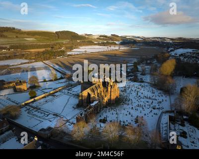 Photo aérienne de l'abbaye de Melrose et de la maison du Commenator avec une couche de neige et de gel au coucher du soleil, le jour d'hiver de décembre. Banque D'Images