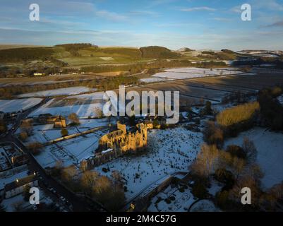 Photo aérienne de l'abbaye de Melrose et de la maison du Commenator avec une couche de neige et de gel au coucher du soleil, le jour d'hiver de décembre. Banque D'Images