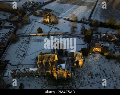 Photo aérienne de l'abbaye de Melrose et de la maison du Commenator avec une couche de neige et de gel au coucher du soleil, le jour d'hiver de décembre. Banque D'Images