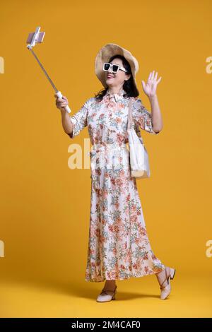 Une femme chinoise joyeuse prend le selfie avec un smartphone Banque D'Images