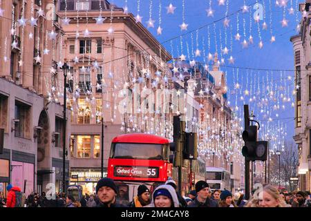 Des clients heureux sous les lumières de Noël à Oxford Street, Londres à Noël Banque D'Images