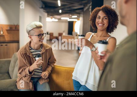 Deux employées de bureau appréciant la communication avec leur collègue Banque D'Images