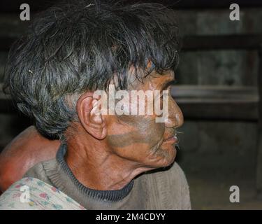 Mon, Nagaland, Inde - 03 02 2009 : gros plan portrait en intérieur du chasseur de tête de la tribu de Naga Konyak, guerrier avec tatouage facial traditionnel Banque D'Images