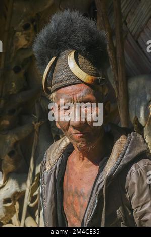 Mon, Nagaland, Inde - 11 25 2013 : Portrait de l'ancien chasseur de tête de tribu Naga Konyak guerrier avec tatouage facial et thoracique portant un chapeau de canne traditionnel Banque D'Images