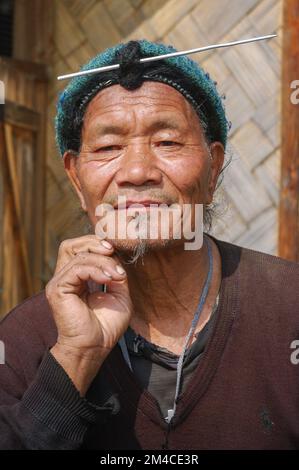 Ziro, Arunachal Pradesh, Inde - 03 04 2014 : Portrait d'un homme tribal d'Apatani d'âge moyen avec un cheveu frontal traditionnel et une aiguille portant une casquette bleue Banque D'Images