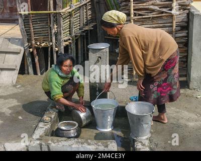 Ziro, Arunachal Pradesh, Inde - 03 04 2014 : femmes tribales locales d'Apatani avec tatouages faciaux traditionnels et bouchons de nez pots de nettoyage au robinet du village Banque D'Images