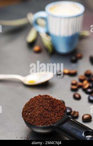 Vous pouvez encore vivre avec du café moulu au premier plan, des grains de café derrière et une tasse en arrière-plan Banque D'Images