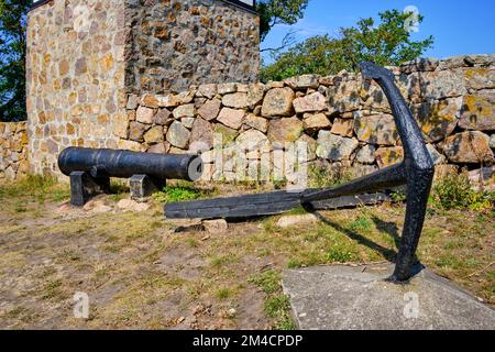 Sur les îles Ertholmen, vieux canon et ancre de bateau devant le clocher séparé de l'ancienne église de Christiansö, Ertholmene, Danemark. Banque D'Images