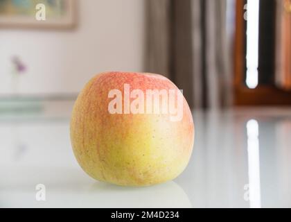 gros plan d'une pomme sur une table blanche brillante Banque D'Images