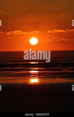 Un cliché vertical d'un magnifique coucher de soleil avec le reflet dans les eaux à Hardelot, France Banque D'Images