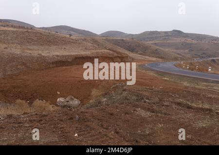 La roue de voiture suit sur une terre à côté du virage de la route asphaltée Banque D'Images