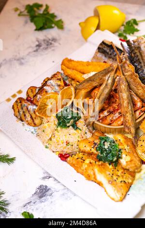 un ensemble de différents plats de poisson sur une assiette blanche. Banque D'Images