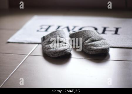 Chaussons sur un tapis à l'entrée avec une faible profondeur de champ Banque D'Images