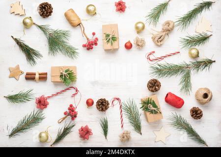 Noël arrière-plan de création d'objets divers, y compris des boîtes-cadeaux, des bâtons de cannelle, fruits décoratifs sur une table en bois blanc, copie espace au milieu, sur le tableau blanc, selective focus Banque D'Images