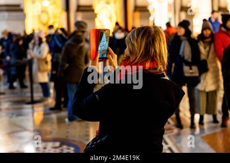 Milan, Italie. 20th décembre 2022. Une femme photographie l'arbre de Noël Swarovski dans la galerie Vittorio Emanuele dans l'atmosphère de Noël à Milan. (Photo de Mairo Cinquetti/SOPA Images/Sipa USA) crédit: SIPA USA/Alay Live News Banque D'Images