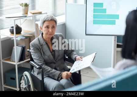 Portrait d'une femme cadre en fauteuil roulant au bureau pendant la réunion Banque D'Images