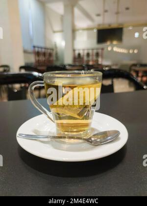 Tasse de thé en verre à la camomille chaude sur la table du restaurant. Mise au point sélective Banque D'Images