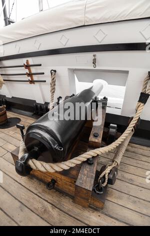 détails d'un vieux canon en métal avec cordes sur un navire avec un plancher en bois, assembler l'ancien militaire comme un étalage, outils nautiques Banque D'Images