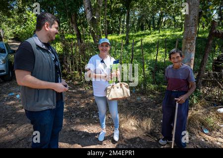 La Labor, la Libertad, Salvador - 27 octobre 2022 - Salvadorienne femme avec deux hommes parlent et sourient dans la campagne Banque D'Images